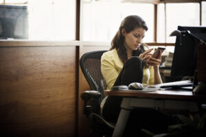 a woman sitting at a table using a laptop computer